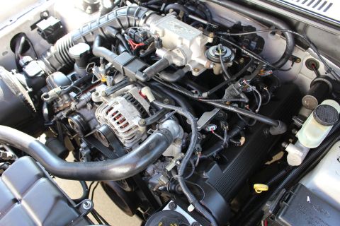 2002 Ford Mustang - Close-up view of a Ford Mustang engine, highlighting the complex network of hoses and electrical components.
