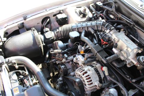2002 Ford Mustang - Engine bay of a 2002 Ford Mustang, showing the V8 engine and associated parts.