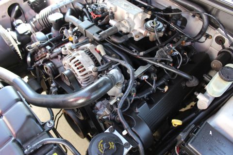 2002 Ford Mustang - The engine bay of a 2002 Ford Mustang is visible, displaying its V8 engine components and associated wiring.