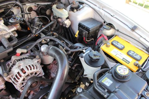 2002 Ford Mustang - Close-up view of a Ford Mustang engine bay with various components visible.