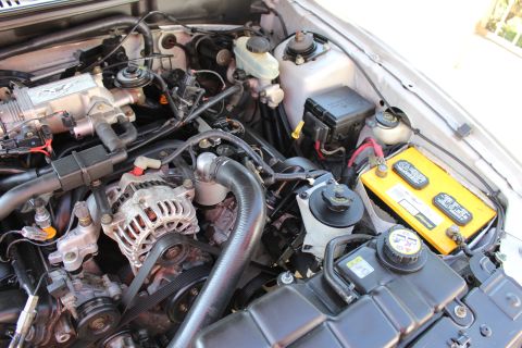 2002 Ford Mustang - Close-up of the engine bay in a 2002 Ford Mustang, highlighting the motor and associated parts.