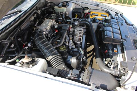 2002 Ford Mustang - Engine bay of a 2002 Ford Mustang, showing the V8 engine, air intake, and battery.