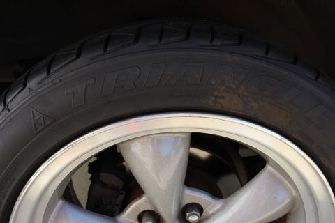 2002 Ford Mustang - A close-up view of a vehicle's tire and wheel assembly, showing the brand name on the tire.