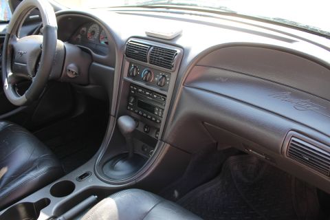 2002 Ford Mustang - The interior of a 2002 Ford Mustang is visible, including the dashboard and seating.