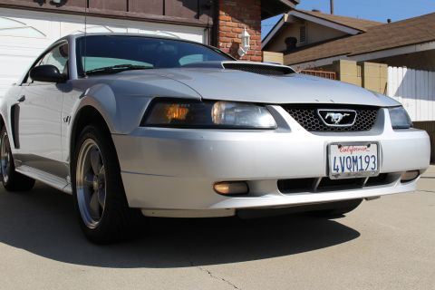 2002 Ford Mustang - Silver 2002 Ford Mustang with a California license plate is parked in front of a garage.