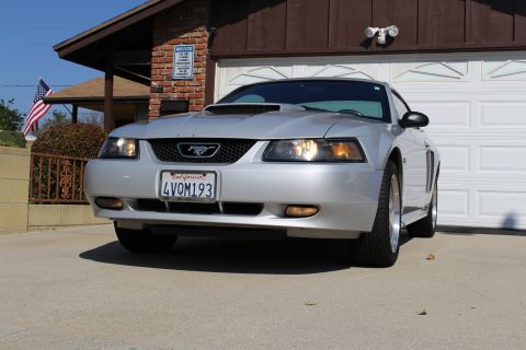 2002 Ford Mustang - This silver 2002 Ford Mustang is parked in front of a garage.