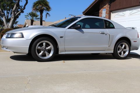 2002 Ford Mustang - Side view of a silver 2002 Ford Mustang GT with a spoiler and GT badging.