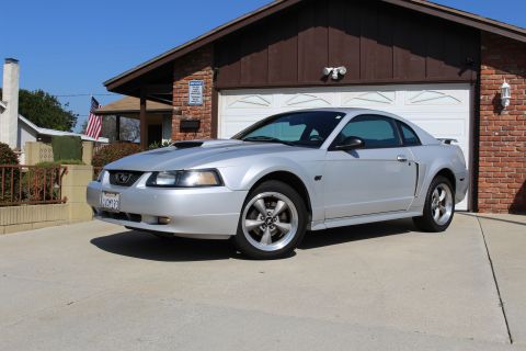 2002 Ford Mustang - This 2002 Ford Mustang is parked in front of a garage with a brick facade.