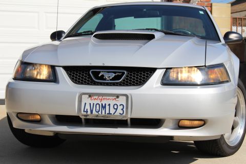 2002 Ford Mustang - The front grille of a silver Ford Mustang features the iconic running horse emblem.