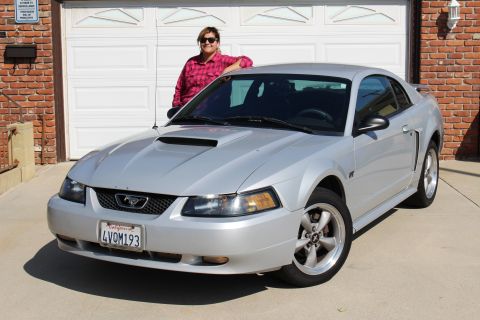 2002 Ford Mustang - Silver 2002 Ford Mustang with a woman posing in front of a garage door.