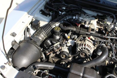2002 Ford Mustang - Close-up view of a vehicle's engine compartment, showing various components like the air intake system and alternator.