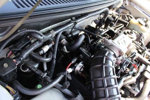 2002 Ford Mustang - Close-up view of a vehicle's engine bay, showing various mechanical parts and wiring.