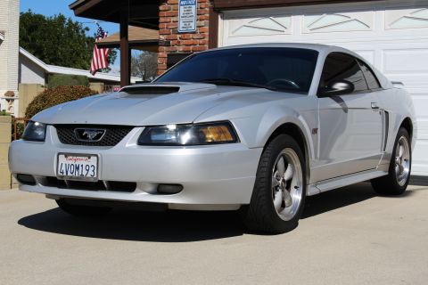 2002 Ford Mustang - This 2002 Ford Mustang coupe is parked in a driveway with a garage in the background.