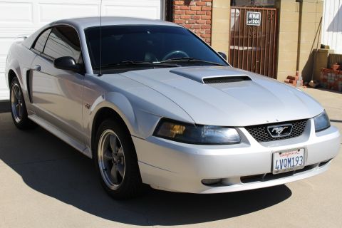 2002 Ford Mustang - A silver Ford Mustang GT is parked in front of a garage door, with a 'Beware of Dog' sign visible on the gate.