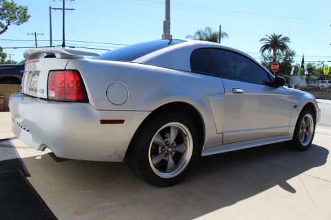 2002 Ford Mustang - Rear quarter view of a silver 2002 Ford Mustang, showing its distinctive body style and spoiler.