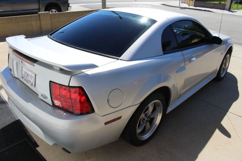 2002 Ford Mustang - Rear quarter view of a silver 2002 Ford Mustang coupe with tinted windows and a rear spoiler.
