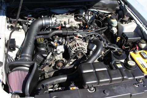 2002 Ford Mustang - The engine bay of a vehicle, an aftermarket air intake system and K&N air filter.