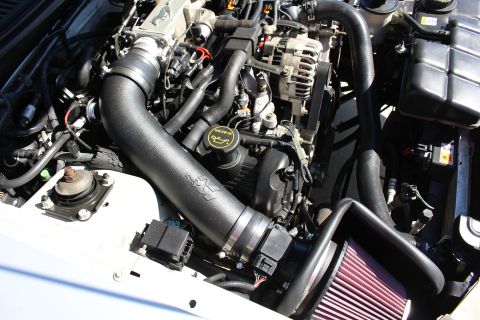 2002 Ford Mustang - Close-up of a K&N cold air intake system installed in a vehicle's engine bay.
