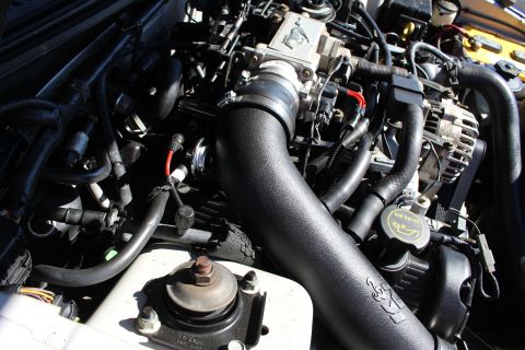 2002 Ford Mustang - Engine bay of a 2002 Ford Mustang, an aftermarket intake system and visible Mustang badging.