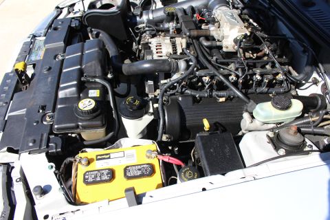 2002 Ford Mustang - The engine bay of a 2002 Ford Mustang is shown, the V8 engine and various components.