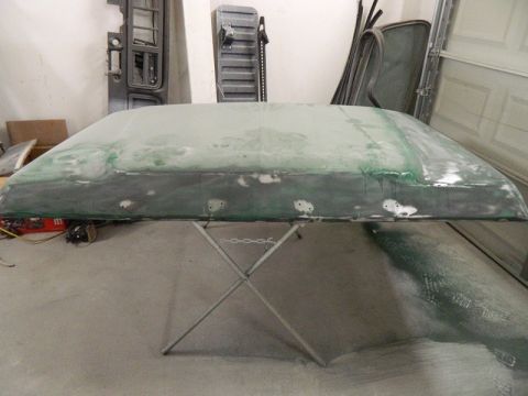 1979 Ford Bronco - A car roof section is being prepped for paint in a garage.