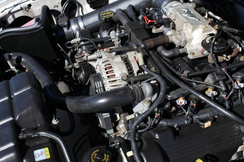 2002 Ford Mustang - Close-up of a 2002 Ford Mustang engine bay, highlighting the V8 engine components and intake system.