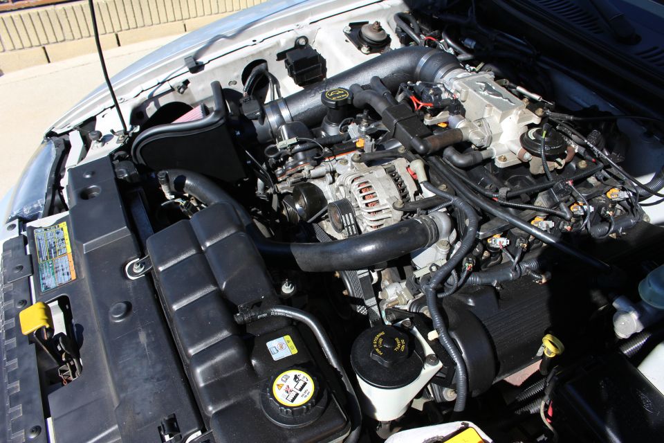 2002 Ford Mustang engine bay with aftermarket intake. Silver paint visible on fender