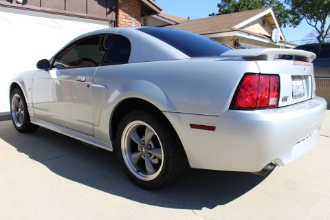 2002 Ford Mustang - Rear three-quarter view of a silver Ford Mustang GT coupe with a spoiler and tinted windows.