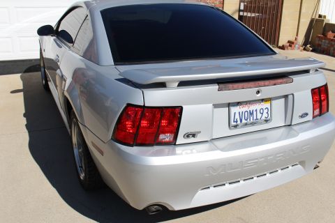 2002 Ford Mustang - Rear view of a silver 2002 Ford Mustang GT, tinted windows and a rear spoiler.