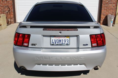 2002 Ford Mustang - Silver 2002 Ford Mustang GT parked in front of a garage door.