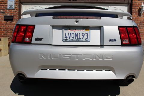 2002 Ford Mustang - Rear view of a silver 2002 Ford Mustang GT, showing its distinctive taillights and "MUSTANG" badging.