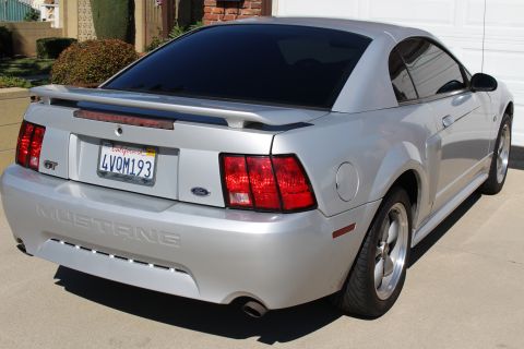 2002 Ford Mustang - Rear view of a silver 2002 Ford Mustang GT with tinted windows and a spoiler.