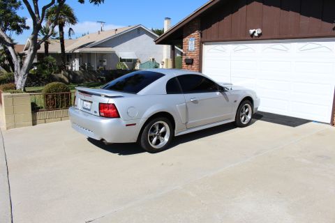 2002 Ford Mustang - Silver 2002 Ford Mustang coupe with tinted windows parked in a suburban driveway.
