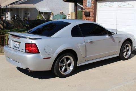 2002 Ford Mustang - Silver 2002 Ford Mustang coupe with tinted windows and a rear spoiler.