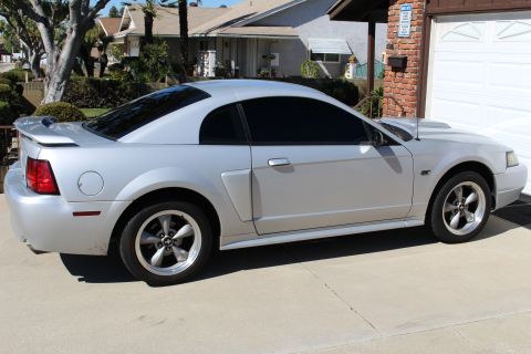 2002 Ford Mustang - Side view of a silver 2002 Ford Mustang coupe with tinted windows.