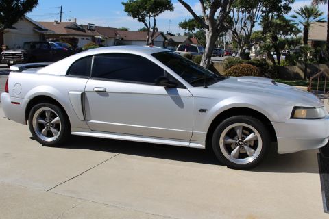 2002 Ford Mustang - Side view of a silver 2002 Ford Mustang coupe parked outdoors.