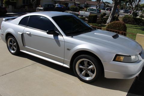 2002 Ford Mustang - Silver 2002 Ford Mustang GT with tinted windows and a hood scoop.