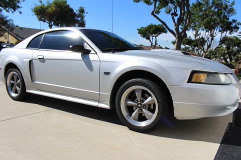 2002 Ford Mustang - A silver 2002 Ford Mustang GT is shown from the front three-quarter view on a paved surface.