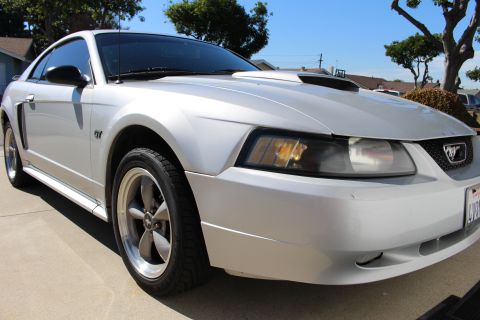 2002 Ford Mustang - Silver 2002 Ford Mustang GT with aftermarket hood scoop and GT badging.