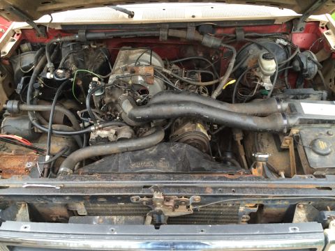 1989 Ford Bronco - Engine bay of a vehicle, showing the engine, fan, and radiator components.