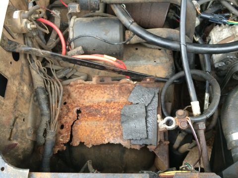 1989 Ford Bronco - The battery tray in this engine bay is severely corroded and shows signs of damage.