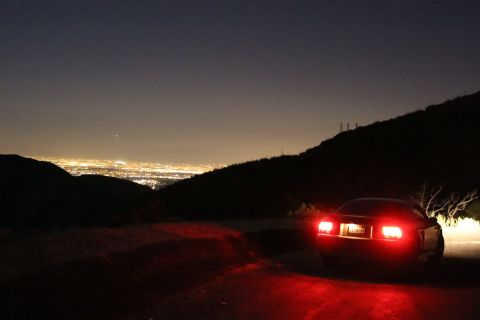 2002 Ford Mustang - Rear view of a 2002 Ford Mustang parked on a hillside overlooking a city at night.