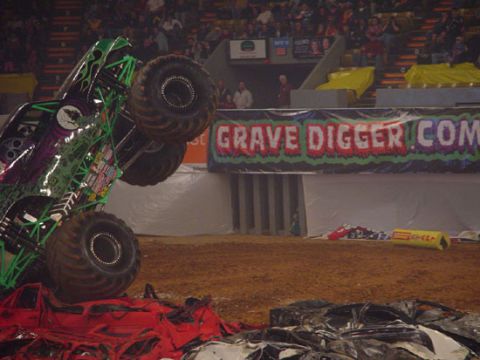 1989 Ford Bronco - A monster truck is shown on its side, crushing several cars during an event.