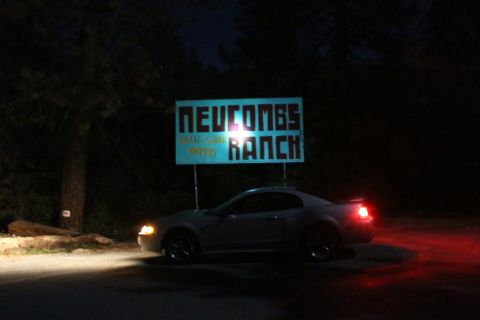 2002 Ford Mustang - A silver 2002 Ford Mustang is parked at night near a sign for Newcombs Ranch.