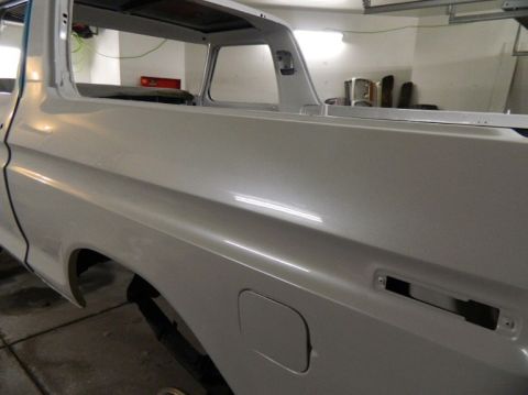 1979 Ford Bronco - Side view of a 1979 Ford Bronco body undergoing restoration in a garage.