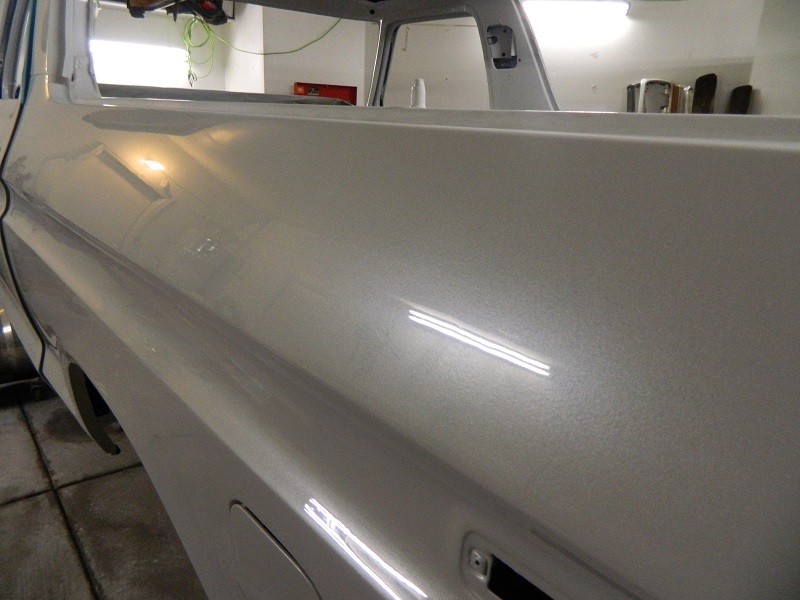 close-up of a silver vehicle's side panel, showing metallic paint flecks