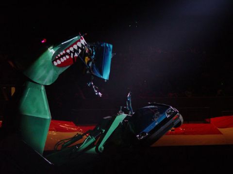 1989 Ford Bronco - Robot with shark teeth appears to be attacking a car during a show.