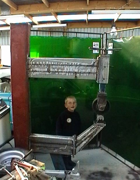 1969 MINI Cooper - A young boy stands in a workshop next to a metal shaping machine.