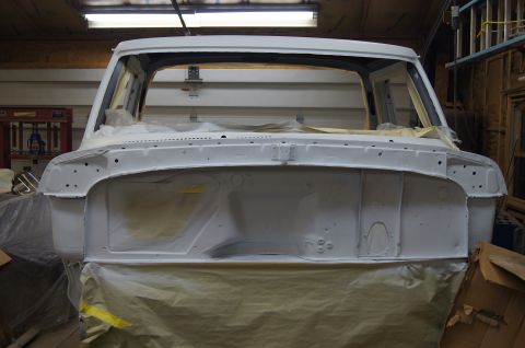 1979 Ford Bronco - Front view of a white truck cab, prepped for painting, with masking paper covering the lower sections.