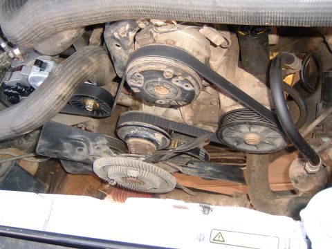 1987 Ford Bronco - Close-up view of an engine bay, focusing on the water pump and associated belt system.